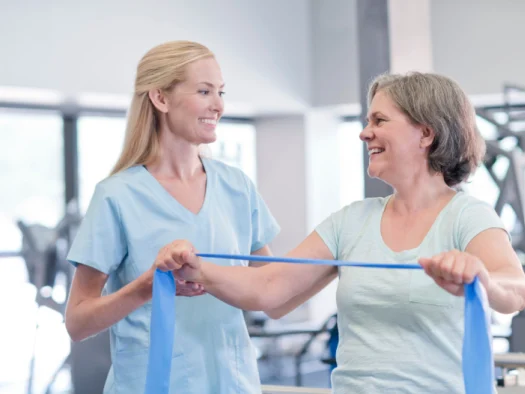 Female physiotherapist assisting an older patient during a treatment session