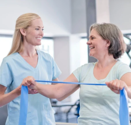 Female physiotherapist assisting an older patient during a treatment session